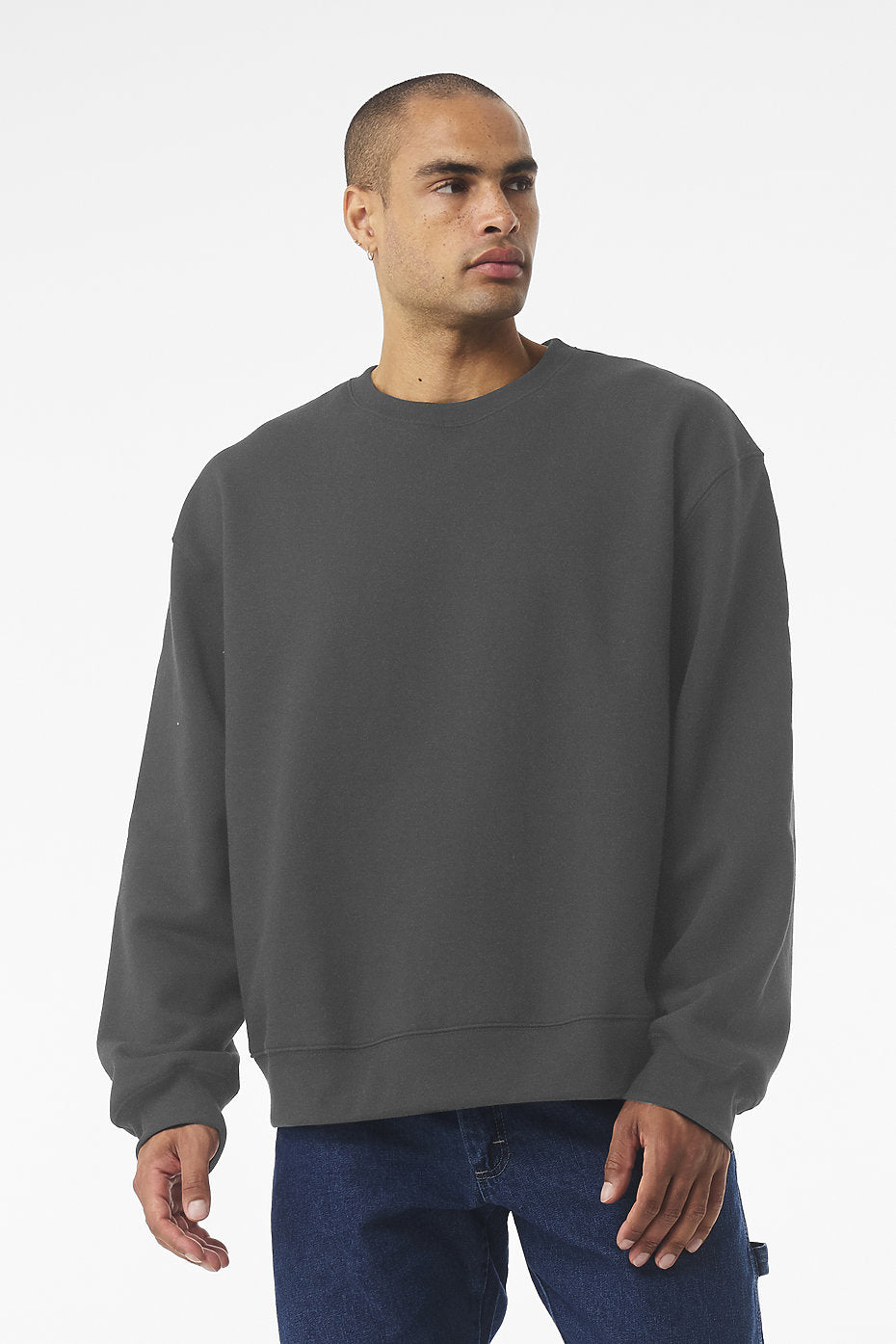 Man wearing dark gray unisex heavyweight crewneck sweatshirt with relaxed fit and dropped sleeves